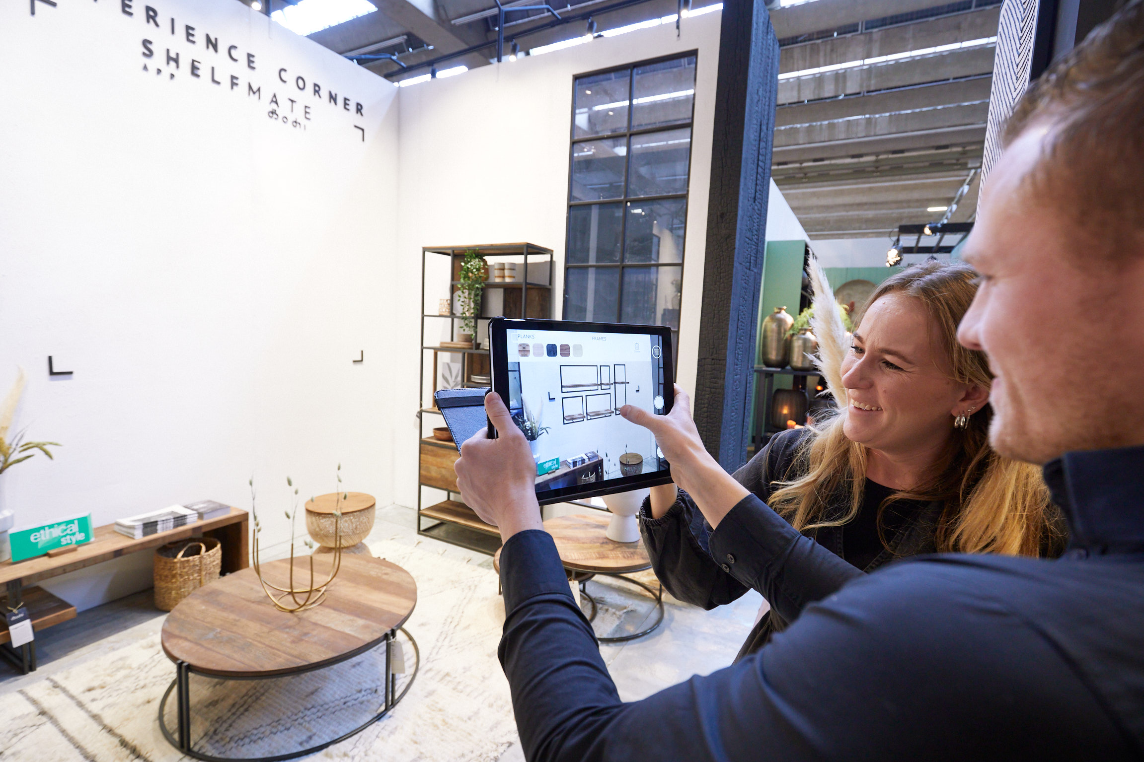 Woman and man at a tablet in front of a trade fair stand